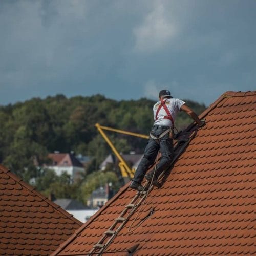 Roofing contractor on top of roof.